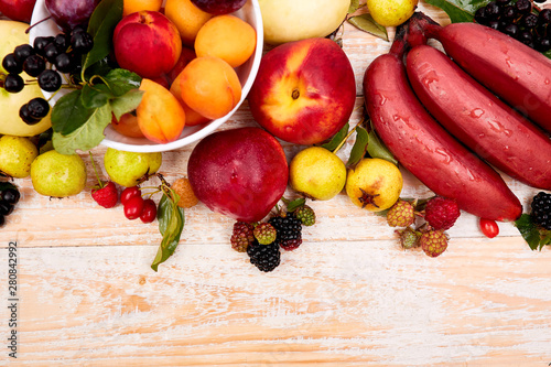 Flat lay of fruits over white wooden background  top view. Vegetarian  vegan  dieting  clean eating  weight loss ingredients.  Summer fruit food background. Copy space.