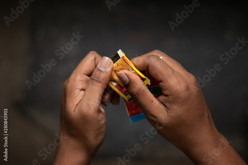 Close up of a man hand tearing the Chewing tobacco, Gutka or gutkha in India.