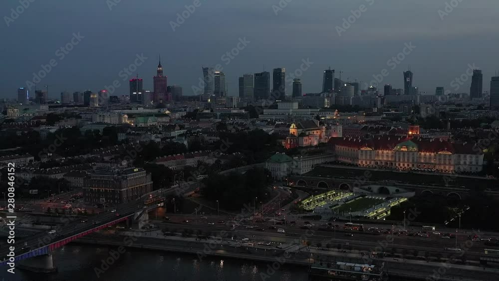 Flight of the drone over the night city of Warsaw. Aerial view of the beautiful cityscape with traffic and the old town. Royal palace is beautifully lit by lanterns at sunset. Drone Shot 4K. Flight of the drone over the night city of Warsaw. Aerial view of the beautiful cityscape with traffic and the old town. Royal palace is beautifully lit by lanterns at sunset. Drone Shot 4K.