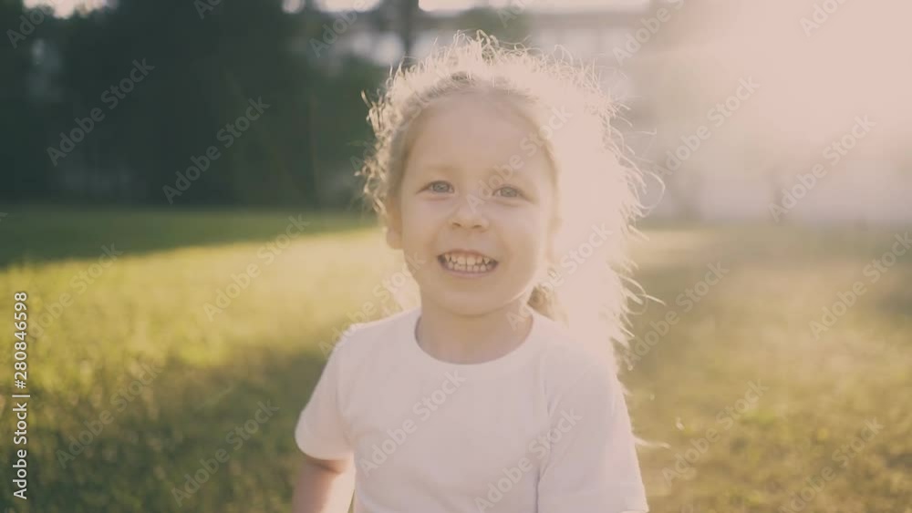 cheerful little girl catches butterflies with net playing at back sunlight creating halo in green summer park closeup cheerful little girl catches butterflies with net playing at back sunlight creating halo in green summer park closeup
