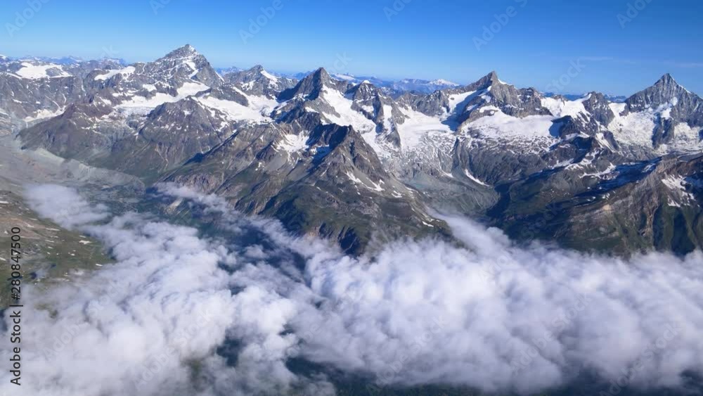 Aerial high altitude panning shot over Zermatt valley under the fog and famous Swiss summits, ending with the Matterhorn. Valais, Switzerland Aerial high altitude panning shot over Zermatt valley under the fog and famous Swiss summits, ending with the Matterhorn. Valais, Switzerland