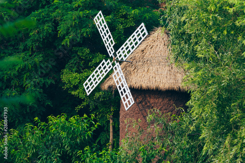 Outdoor turning barn windmill and green woods photo