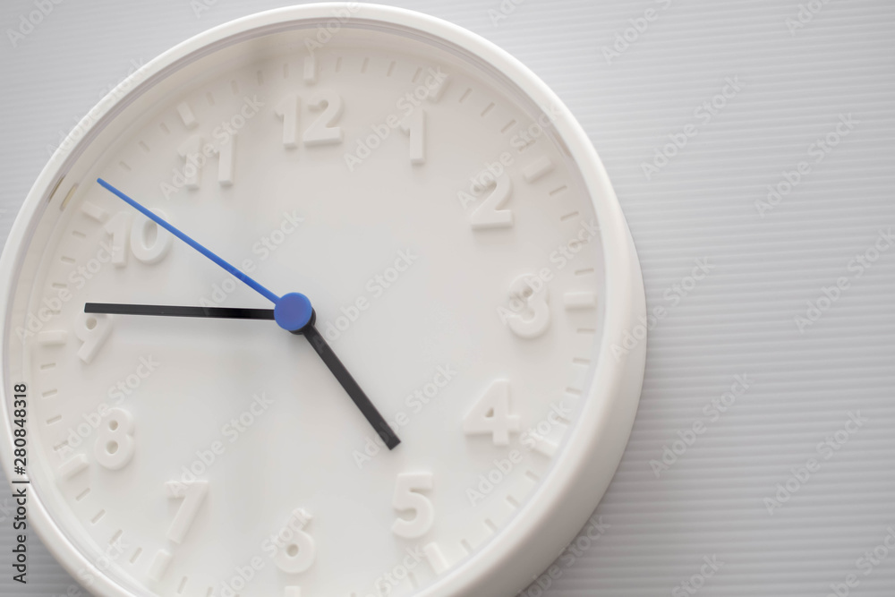 Clock face showing five o'clock with white background. White round wall clock. Five o'clock. off for work. 5 a.m. or 5 p.m