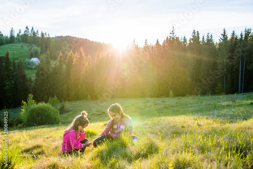 Cheerful children bathed in the evening sun on the edge of the forest