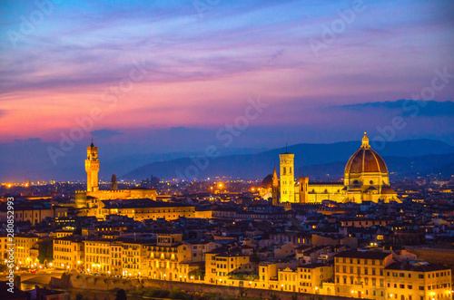 Top aerial panoramic evening view of Florence city with Duomo Cattedrale di Santa Maria del Fiore cathedral and Palazzo Vecchio palace at night dusk twilight, city lights, blue sky, Tuscany, Italy