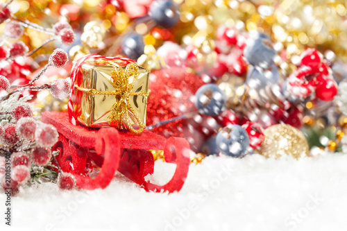 Christmas composition with red Xmas sleigh, gift and snowfall