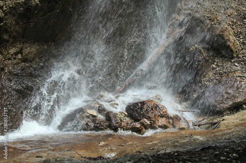 Splashing water on rocks from a falling waterfall © Piotr