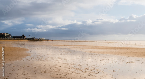 Lytham St. Anne's, Lancashire England UK A bright winter morning at low tide on the beach with dramatic sky and reflections.