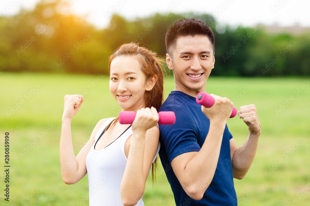 Obraz premium asian young couple training with dumbbells