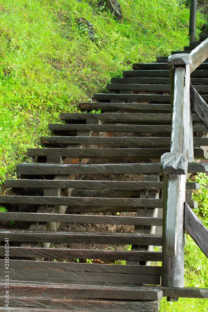 wooden staircase leading up against a background of green grass