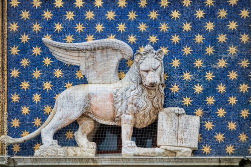 geflügelter löwe am historischen uhrenturm in venedig, italien