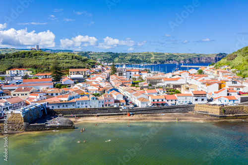Idyllic beach Praia and azure bay Baia do Porto Pim. Fortifications, walls, gates, red roofs of historical touristic Horta town centre, yachts in the port, Faial island, Azores, Portugal, Europe photo