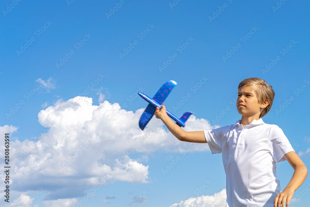 Kid playing with blue toy plane against blue sky Kid playing with blue toy plane against blue sky