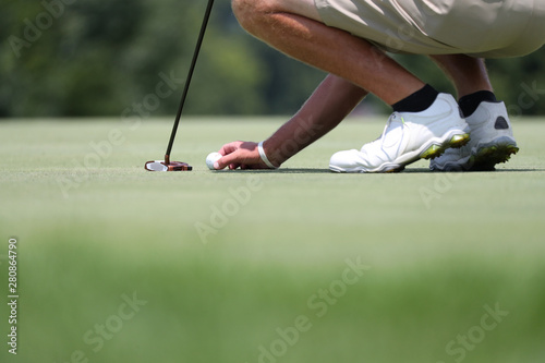 A golfer marks his ball prior to putting