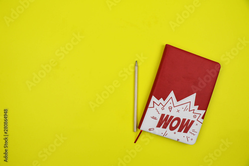 notebook and pencil on a yellow background