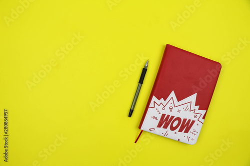 notebook and pencil on a yellow background