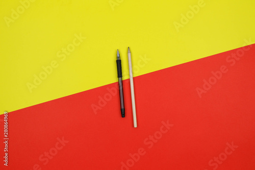 pen end pencil on a yellow and red background