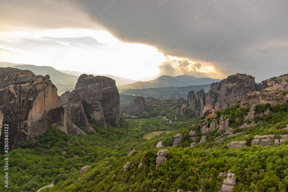 Wonderful view of the rocks and monasteries of Meteora, Greece. Mysterious Sunny evening with colorful sky, during sunset. Awesome Nature Landscape. Amazing Greece. Popular travel locations