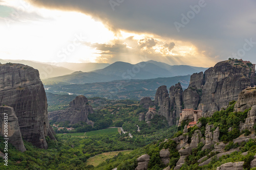Wonderful view of the rocks and monasteries of Meteora, Greece. Mysterious Sunny evening with colorful sky, during sunset. Awesome Nature Landscape. Amazing Greece. Popular travel locations