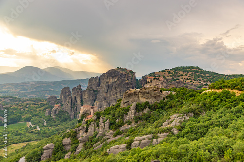 Wonderful view of the rocks and monasteries of Meteora, Greece. Mysterious Sunny evening with colorful sky, during sunset. Awesome Nature Landscape. Amazing Greece. Popular travel locations