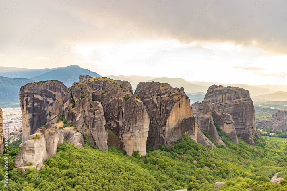 Wonderful view of the rocks and monasteries of Meteora, Greece. Mysterious Sunny evening with colorful sky, during sunset. Awesome Nature Landscape. Amazing Greece. Popular travel locations