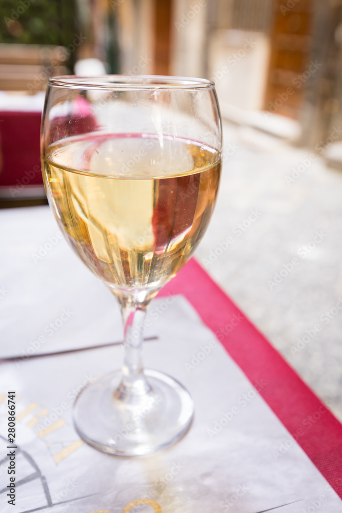 Wine Glass of white wine on the table in a restaurant outside over blurred background