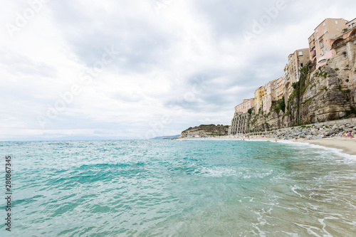 Fototapeta Naklejka Na Ścianę i Meble -  Tropea town and beach coastline of Tyrrhenian Sea with turquoise water, colorful buildings on top of high big rocks, view from Sanctuary church of Santa Maria dell Isola, Calabria, Southern Italy
