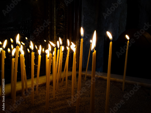 Close-up of  illuminated burning  candles in temple .