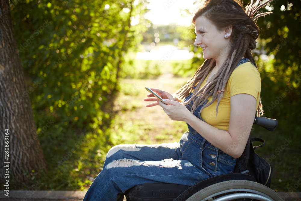 smiling disabled girl having fun with her smart phone. close up side view photo. happiness concept smiling disabled girl having fun with her smart phone. close up side view photo. happiness concept