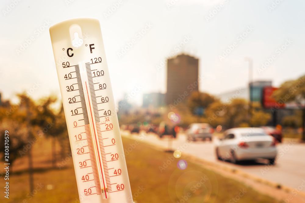 Thermometer in front of an urban scene during heatwave - obrazy, fototapety, plakaty 