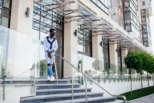 Street style. African american man in  casual suit stay on stairs. © Тарас Нагирняк