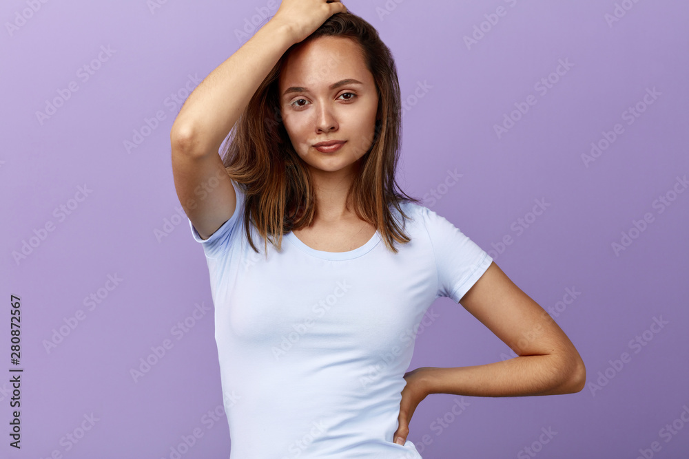 gorgouse girl with a hand on her head and arm on her hip looking at the camera. close up portrait . girl having a rest . leisure time