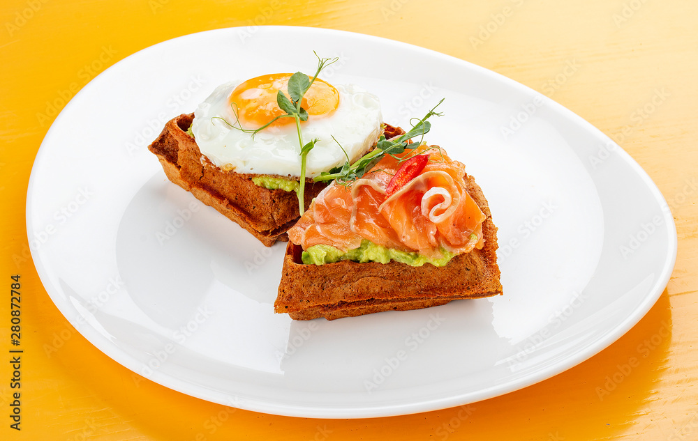 American waffle with salmon and egg, with avocado mousse. Healthy breakfast. American waffle with salmon and egg, with avocado mousse. Healthy breakfast.