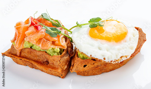 American waffle with salmon and egg  with avocado mousse. Healthy breakfast.