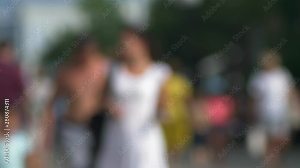 blurred background. A crowd of unrecognizable people walking on a sunny summer day. blurred background. A crowd of unrecognizable people walking on a sunny summer day.