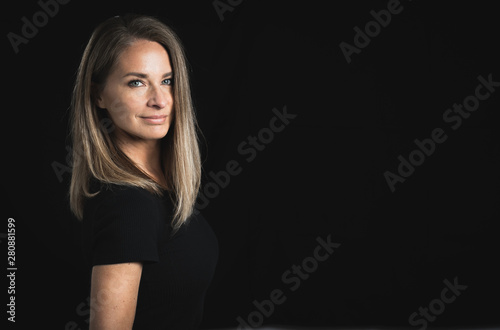 Beautiful middle aged woman on black background with space for text