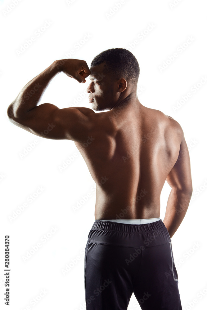african fit man showing biceps, beautiful body, isolated white background. back view photo