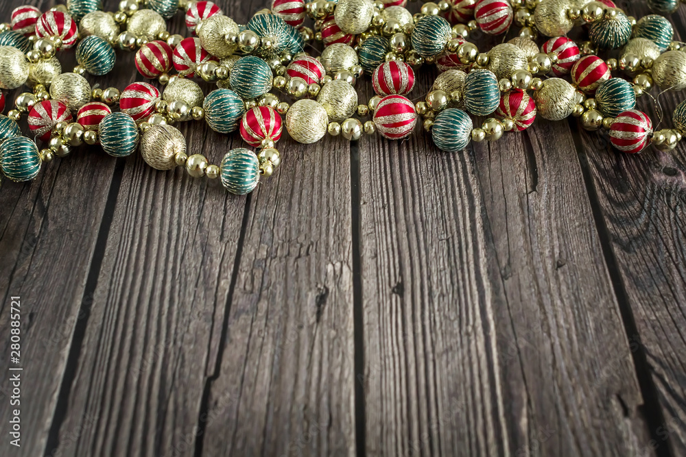 New year concept. Colorful Christmas beads on dark wooden background. Top view, flat lay composition.