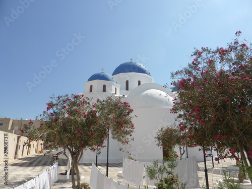 Iconic Blue and White Domed Church and garden in Santorini