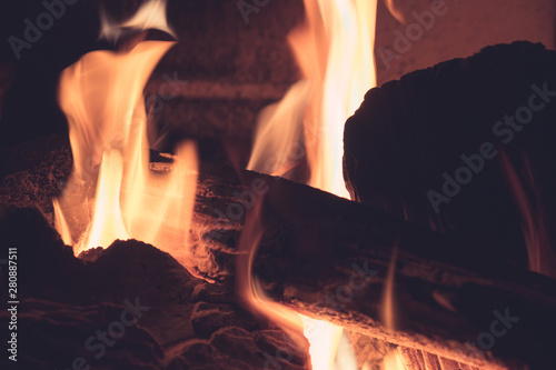 Blur of glowing ember log in the hot red color. Closeup of Firewood burning in the fireplace concept. Orange bokeh from the fire.