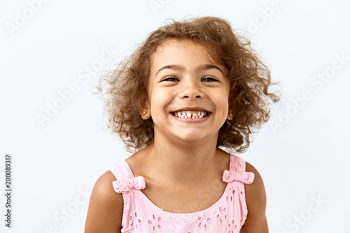 Little African American girl portrait against white background. Blissful,laughter and joy emotions