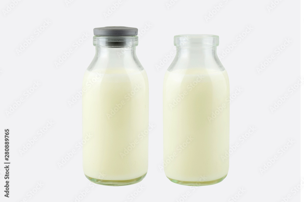 Fresh milk in a transparent bottle with and without lid, isolated on white background, frontside Fresh milk in a transparent bottle with and without lid, isolated on white background, frontside