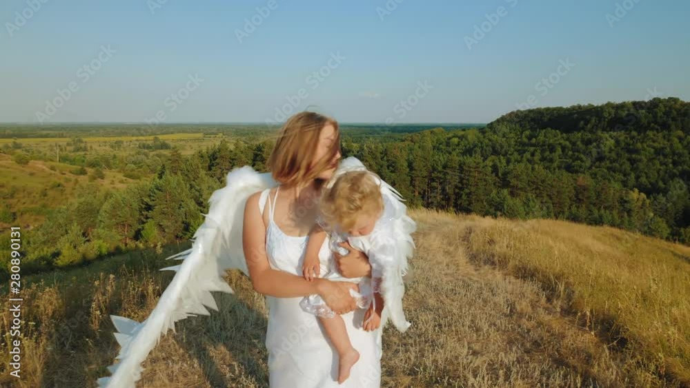 A girl with a child in her arms is dressed like angels A girl with a child in her arms is dressed like angels