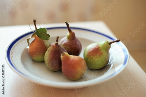 five pears in a plate on a table