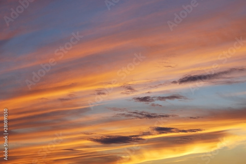 Beautiful vivid sunset sky with floccus clouds lit by setting sun. © Enso