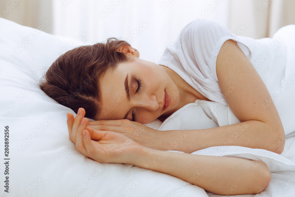 Beautiful young woman sleeping while lying in her bed. Concept of pleasant and rest reinstatement for active life Beautiful young woman sleeping while lying in her bed. Concept of pleasant and rest reinstatement for active life