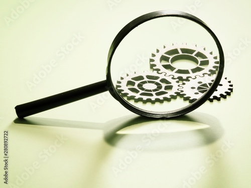 Magnifying glass with gears in the background