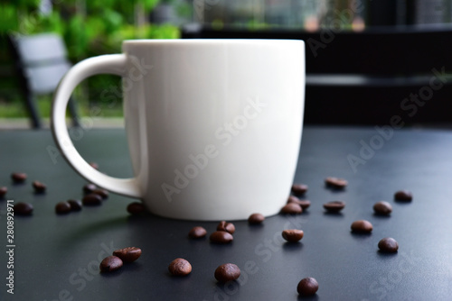 Cap of Coffee on the of dark wood table have many coffee beans. photo