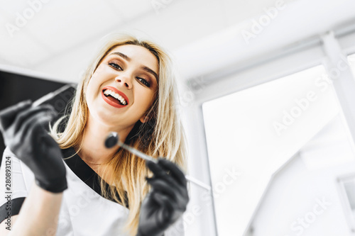 Cuadro en lienzo Portrait of the pretty young female dentist in a dental clinic.