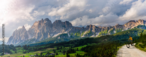 Φωτογραφία Tourist cycling in Cortina d'Ampezzo, stunning rocky mountains on the background